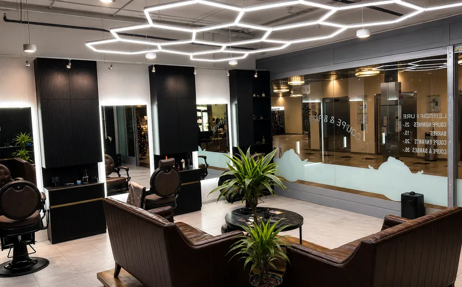 Salon Leli Coiffure à Vernier, éclairage en nid d'abeille et fauteuils en cuir